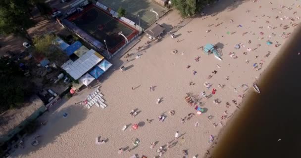 Anténa na pláži. letní slunečný den, lidé se opalovali na žluté pískot na břehu Dněpru řeky město Kyjev. volno, dovolenou na pláži. velký počet turistů plavat. — Stock video