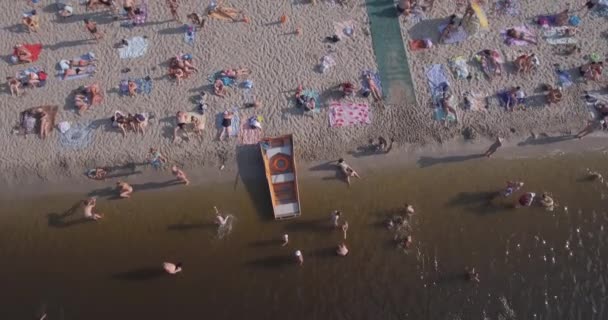 Aerea della spiaggia. estate giornata di sole, la gente sta prendendo il sole su un cigolio giallo sulla riva della città del fiume Dnieper di Kiev. giorno libero, vacanza sulla spiaggia. un gran numero di turisti nuotare . — Video Stock