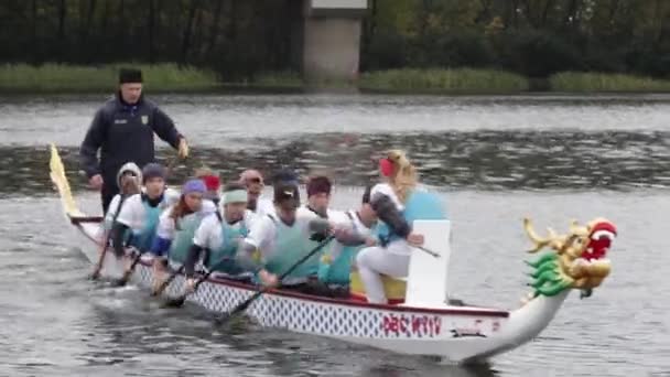 Kano wedstrijden in Kiev op 30 september 2017. De zwemmers race is 5 kilometer naar de rivier Dnipro. Kano 10 zetel in de boeg van de boot hoofd van de draak. — Stockvideo
