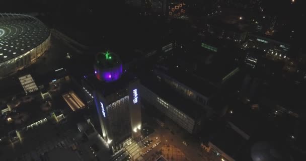 夜キエフ都市スカイラインの建物の眺め.大都市の背景。ニューヨークのショットを確立します。摩天楼の街並みと近代的な都市で照らされた通りの垂直空中夜景. — ストック動画