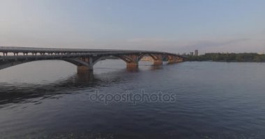 Hava. Ukrayna şehir Kiev. Metro Dnieper İstasyonu'na varış. 2017.06.09. metro Dnieper Nehri Köprüsü. Yaz alacakaranlık, köprü Idol Dnepr metro Köprüsü yukarıdaki arabaları.