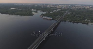 Hava. Ukrayna şehir Kiev. Metro Dnieper İstasyonu'na varış. 2017.06.09. metro Dnieper Nehri Köprüsü. Yaz alacakaranlık, köprü Idol Dnepr metro Köprüsü yukarıdaki arabaları.