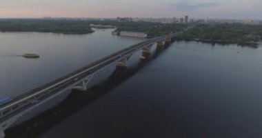 Hava. Ukrayna şehir Kiev. Metro Dnieper İstasyonu'na varış. 2017.06.09. metro Dnieper Nehri Köprüsü. Yaz alacakaranlık, köprü Idol Dnepr metro Köprüsü yukarıdaki arabaları.