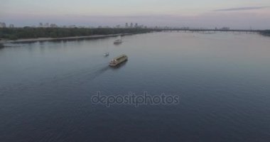 Hava. Römorkör mavna ile Nehri boyunca römorkör hamle Nehri üzerinde bir yük taşır. Kiev şehir. Ukrayna. 2017.06.07. gün batımında güneş Nehri boyunca, bir römorkör kargo ile.