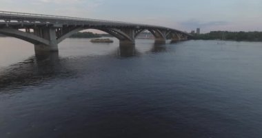 Hava. Ukrayna şehir Kiev. Metro Dnieper İstasyonu'na varış. 2017.06.09. metro Dnieper Nehri Köprüsü. Yaz alacakaranlık, köprü Idol Dnepr metro Köprüsü yukarıdaki arabaları.