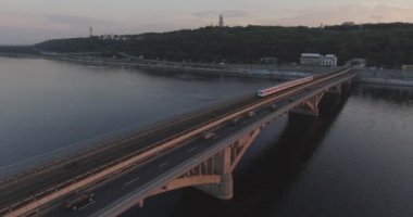 Hava. Ukrayna şehir Kiev. Metro Dnieper İstasyonu'na varış. 2017.06.09. metro Dnieper Nehri Köprüsü. Yaz alacakaranlık, köprü Idol Dnepr metro Köprüsü yukarıdaki arabaları.