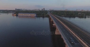 Hava. Ukrayna şehir Kiev. Metro Dnieper İstasyonu'na varış. 2017.06.09. metro Dnieper Nehri Köprüsü. Yaz alacakaranlık, köprü Idol Dnepr metro Köprüsü yukarıdaki arabaları.