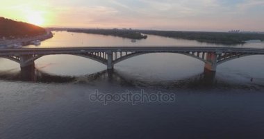 Hava. Ukrayna şehir Kiev. Metro Dnieper İstasyonu'na varış. 2017.06.09. metro Dnieper Nehri Köprüsü. Yaz alacakaranlık, köprü Idol Dnepr metro Köprüsü yukarıdaki arabaları.
