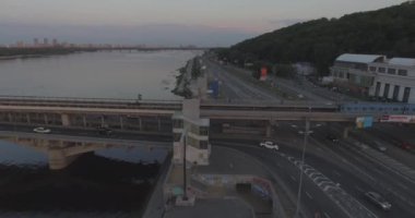 Hava. Ukrayna şehir Kiev. Metro Dnieper İstasyonu'na varış. 2017.06.09. metro Dnieper Nehri Köprüsü. Yaz alacakaranlık, köprü Idol Dnepr metro Köprüsü yukarıdaki arabaları.