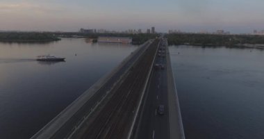 Hava. Ukrayna şehir Kiev. Metro Dnieper İstasyonu'na varış. 2017.06.09. metro Dnieper Nehri Köprüsü. Yaz alacakaranlık, köprü Idol Dnepr metro Köprüsü yukarıdaki arabaları.