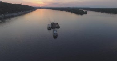 Hava. Römorkör mavna ile Nehri boyunca römorkör hamle Nehri üzerinde bir yük taşır. Kiev şehir. Ukrayna. 2017.06.07. gün batımında güneş Nehri boyunca, bir römorkör kargo ile.