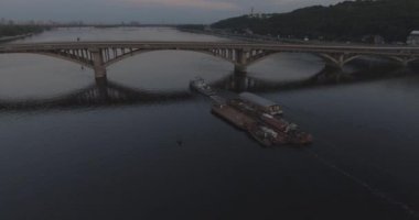 Hava. Römorkör mavna ile Nehri boyunca römorkör hamle Nehri üzerinde bir yük taşır. Kiev şehir. Ukrayna. 2017.06.07. gün batımında güneş Nehri boyunca, bir römorkör kargo ile.