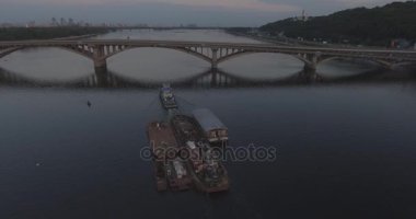 Hava. Römorkör mavna ile Nehri boyunca römorkör hamle Nehri üzerinde bir yük taşır. Kiev şehir. Ukrayna. 2017.06.07. gün batımında güneş Nehri boyunca, bir römorkör kargo ile.