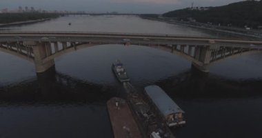 Hava. Römorkör mavna ile Nehri boyunca römorkör hamle Nehri üzerinde bir yük taşır. Kiev şehir. Ukrayna. 2017.06.07. gün batımında güneş Nehri boyunca, bir römorkör kargo ile.