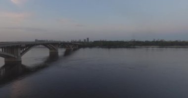 Hava. Ukrayna şehir Kiev. Metro Dnieper İstasyonu'na varış. 2017.06.09. metro Dnieper Nehri Köprüsü. Yaz alacakaranlık, köprü Idol Dnepr metro Köprüsü yukarıdaki arabaları.