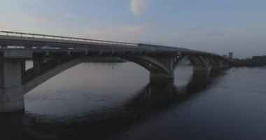 Hava. Ukrayna şehir Kiev. Metro Dnieper İstasyonu'na varış. 2017.06.09. metro Dnieper Nehri Köprüsü. Yaz alacakaranlık, köprü Idol Dnepr metro Köprüsü yukarıdaki arabaları.