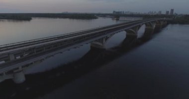 Hava. Ukrayna şehir Kiev. Metro Dnieper İstasyonu'na varış. 2017.06.09. metro Dnieper Nehri Köprüsü. Yaz alacakaranlık, köprü Idol Dnepr metro Köprüsü yukarıdaki arabaları.