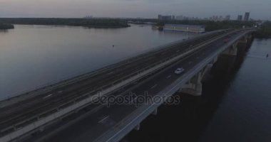 Hava. Ukrayna şehir Kiev. Metro Dnieper İstasyonu'na varış. 2017.06.09. metro Dnieper Nehri Köprüsü. Yaz alacakaranlık, köprü Idol Dnepr metro Köprüsü yukarıdaki arabaları.