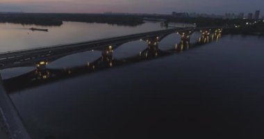 Hava. Ukrayna şehir Kiev. Metro Dnieper İstasyonu'na varış. 2017.06.09. metro Dnieper Nehri Köprüsü. Yaz alacakaranlık, köprü Idol Dnepr metro Köprüsü yukarıdaki arabaları.