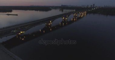 Hava. Ukrayna şehir Kiev. Metro Dnieper İstasyonu'na varış. 2017.06.09. metro Dnieper Nehri Köprüsü. Yaz alacakaranlık, köprü Idol Dnepr metro Köprüsü yukarıdaki arabaları.