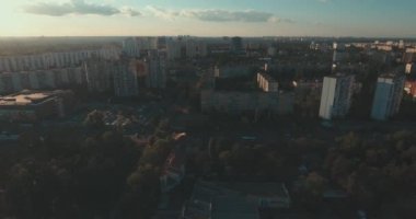 Hava, cadde ve gündoğumu, yüksek binalar. Yaz sabah cityscape üzerinden bir kuş bakışı. Metropol üzerinde uçuş. Güneşli sabah, mavi gökyüzü. Bir sürü yeşil ağaç sokaklarda.