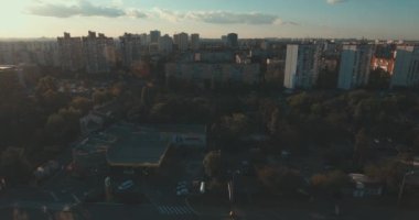 Hava, cadde ve gündoğumu, yüksek binalar. Yaz sabah cityscape üzerinden bir kuş bakışı. Metropol üzerinde uçuş. Güneşli sabah, mavi gökyüzü. Bir sürü yeşil ağaç sokaklarda.