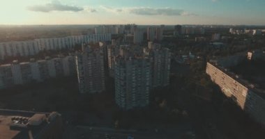 Hava, cadde ve gündoğumu, yüksek binalar. Yaz sabah cityscape üzerinden bir kuş bakışı. Metropol üzerinde uçuş. Güneşli sabah, mavi gökyüzü. Bir sürü yeşil ağaç sokaklarda.