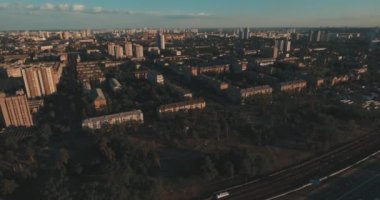 Hava, cadde ve gündoğumu, yüksek binalar. Yaz sabah cityscape üzerinden bir kuş bakışı. Metropol üzerinde uçuş. Güneşli sabah, mavi gökyüzü. Bir sürü yeşil ağaç sokaklarda.