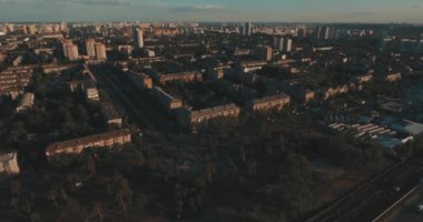 Hava, cadde ve gündoğumu, yüksek binalar. Yaz sabah cityscape üzerinden bir kuş bakışı. Metropol üzerinde uçuş. Güneşli sabah, mavi gökyüzü. Bir sürü yeşil ağaç sokaklarda.