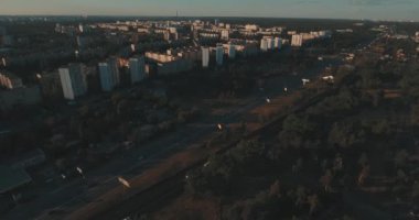 Hava, cadde ve gündoğumu, yüksek binalar. Yaz sabah cityscape üzerinden bir kuş bakışı. Metropol üzerinde uçuş. Güneşli sabah, mavi gökyüzü. Bir sürü yeşil ağaç sokaklarda.