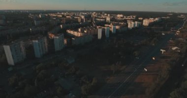 Hava, cadde ve gündoğumu, yüksek binalar. Yaz sabah cityscape üzerinden bir kuş bakışı. Metropol üzerinde uçuş. Güneşli sabah, mavi gökyüzü. Bir sürü yeşil ağaç sokaklarda.