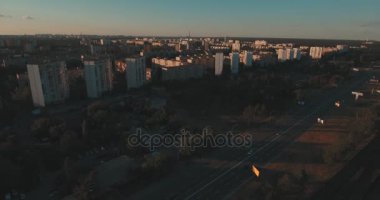 Hava, cadde ve gündoğumu, yüksek binalar. Yaz sabah cityscape üzerinden bir kuş bakışı. Metropol üzerinde uçuş. Güneşli sabah, mavi gökyüzü. Bir sürü yeşil ağaç sokaklarda.