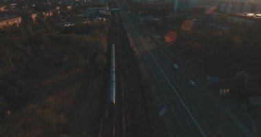 Hava, cadde ve gündoğumu, yüksek binalar. Yaz sabah cityscape üzerinden bir kuş bakışı. Metropol üzerinde uçuş. Güneşli sabah, mavi gökyüzü. Bir sürü yeşil ağaç sokaklarda.