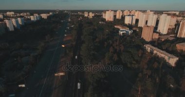 Hava, cadde ve gündoğumu, yüksek binalar. Yaz sabah cityscape üzerinden bir kuş bakışı. Metropol üzerinde uçuş. Güneşli sabah, mavi gökyüzü. Bir sürü yeşil ağaç sokaklarda.