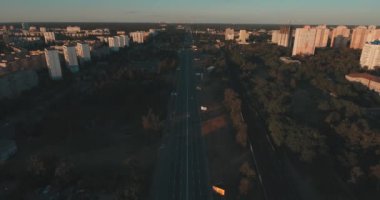 Hava, cadde ve gündoğumu, yüksek binalar. Yaz sabah cityscape üzerinden bir kuş bakışı. Metropol üzerinde uçuş. Güneşli sabah, mavi gökyüzü. Bir sürü yeşil ağaç sokaklarda.