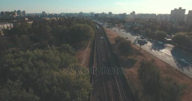 Hava, cadde ve gündoğumu, yüksek binalar. Yaz sabah cityscape üzerinden bir kuş bakışı. Metropol üzerinde uçuş. Güneşli sabah, mavi gökyüzü. Bir sürü yeşil ağaç sokaklarda.