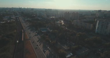 Hava, cadde ve gündoğumu, yüksek binalar. Yaz sabah cityscape üzerinden bir kuş bakışı. Metropol üzerinde uçuş. Güneşli sabah, mavi gökyüzü. Bir sürü yeşil ağaç sokaklarda.