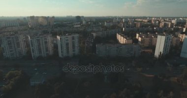 Hava, cadde ve gündoğumu, yüksek binalar. Yaz sabah cityscape üzerinden bir kuş bakışı. Metropol üzerinde uçuş. Güneşli sabah, mavi gökyüzü. Bir sürü yeşil ağaç sokaklarda.