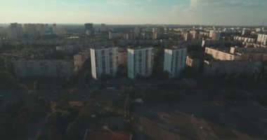 Hava, cadde ve gündoğumu, yüksek binalar. Yaz sabah cityscape üzerinden bir kuş bakışı. Metropol üzerinde uçuş. Güneşli sabah, mavi gökyüzü. Bir sürü yeşil ağaç sokaklarda.