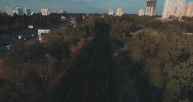 Hava, cadde ve gündoğumu, yüksek binalar. Yaz sabah cityscape üzerinden bir kuş bakışı. Metropol üzerinde uçuş. Güneşli sabah, mavi gökyüzü. Bir sürü yeşil ağaç sokaklarda.