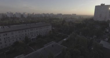 Hava, cadde ve gündoğumu, yüksek binalar. Yaz sabah cityscape üzerinden bir kuş bakışı. Metropol üzerinde uçuş. Güneşli sabah, mavi gökyüzü. Bir sürü yeşil ağaç sokaklarda.