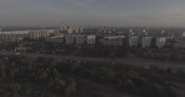 Hava, cadde ve gündoğumu, yüksek binalar. Yaz sabah cityscape üzerinden bir kuş bakışı. Metropol üzerinde uçuş. Güneşli sabah, mavi gökyüzü. Bir sürü yeşil ağaç sokaklarda.
