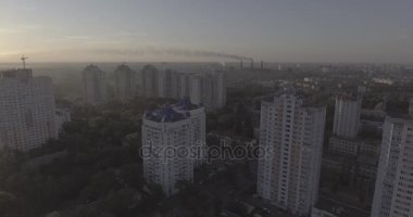 Hava, cadde ve gündoğumu, yüksek binalar. Yaz sabah cityscape üzerinden bir kuş bakışı. Metropol üzerinde uçuş. Güneşli sabah, mavi gökyüzü. Bir sürü yeşil ağaç sokaklarda.