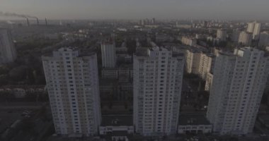 Hava, cadde ve gündoğumu, yüksek binalar. Yaz sabah cityscape üzerinden bir kuş bakışı. Metropol üzerinde uçuş. Güneşli sabah, mavi gökyüzü. Bir sürü yeşil ağaç sokaklarda.