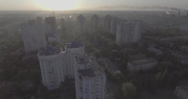 Hava, cadde ve gündoğumu, yüksek binalar. Yaz sabah cityscape üzerinden bir kuş bakışı. Metropol üzerinde uçuş. Güneşli sabah, mavi gökyüzü. Bir sürü yeşil ağaç sokaklarda.