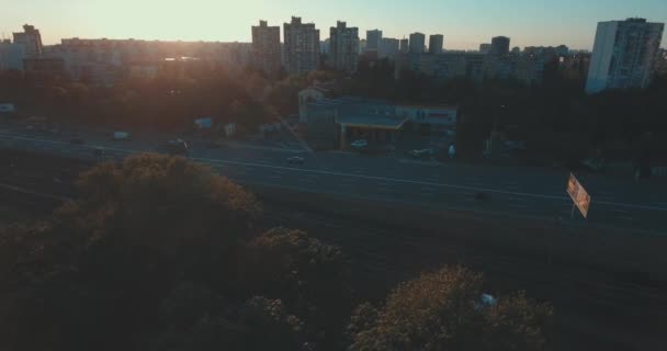 日の出高層建物の航空写真 鳥の目のビューから夏の朝の街並み 大都市以上のフライト 晴れた朝 青い空 路上では緑の木々 の多く — ストック動画