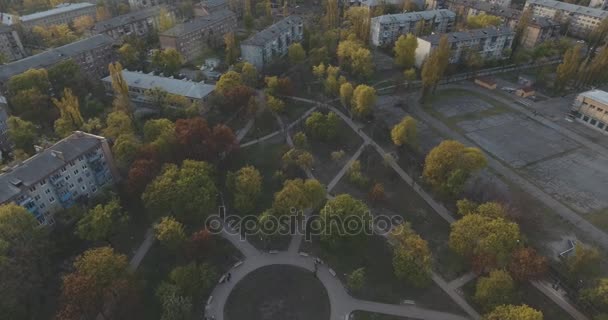 Quartier résidentiel de la ville au coucher du soleil, aérien. Paysage urbain, Parcs et places d'une hauteur. Soirée d'été, appartements, arbres verts. Dnepr River. Sentiers avec des voitures. Les gens se reposent dans le parc .