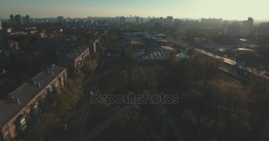 Kentsel peyzaj eski şehir, hava. Cityscape Kiev yukarıdan. Yaz gecesi, günbatımı, evler, yollar ve araçların. İnsanlar kaldırımda yürümek. Şehir çeyreğinde yeşil ağaçlar.