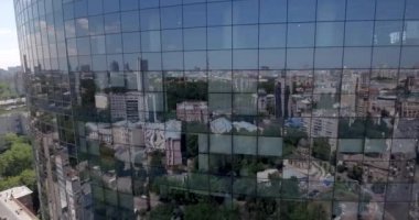 Hava. loseup cam gökdelen, iş binalar bölgesine, küresel ticaret. Pürüzsüz kamera hareketi ofis windows güneşli mavi gökyüzü beyaz bulutlar ile yansıtan binası önünde. 4k