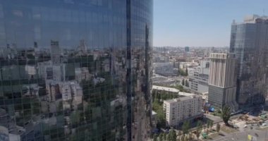 Hava. loseup cam gökdelen, iş binalar bölgesine, küresel ticaret. Pürüzsüz kamera hareketi ofis windows güneşli mavi gökyüzü beyaz bulutlar ile yansıtan binası önünde. 4k